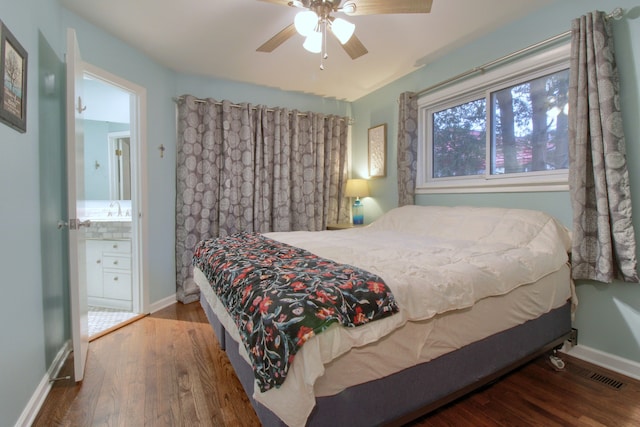 bedroom with visible vents, a sink, baseboards, and wood finished floors