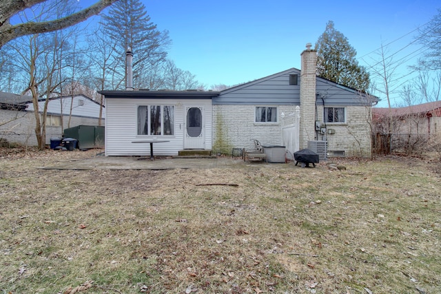 back of property with crawl space, a lawn, a chimney, and fence