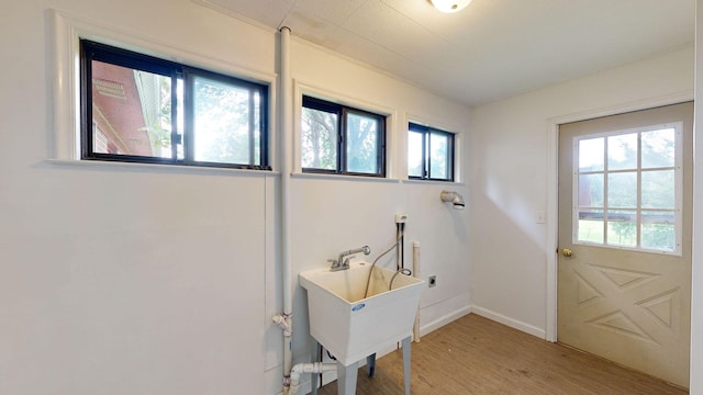 laundry room with a healthy amount of sunlight, laundry area, and light wood-style floors