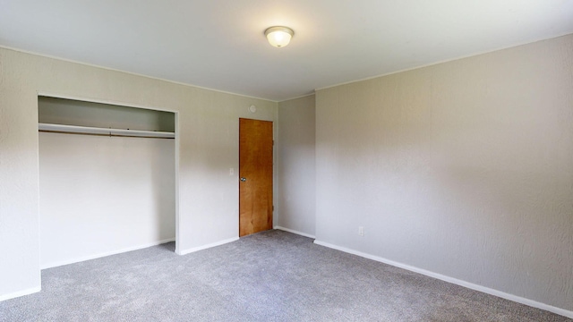 unfurnished bedroom featuring carpet, baseboards, and a closet