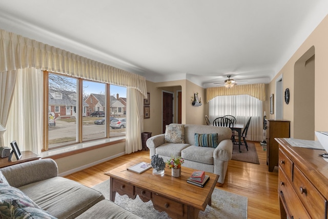 living room with light wood finished floors, plenty of natural light, and baseboards