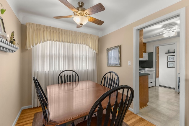 dining space featuring a ceiling fan, light wood-type flooring, and baseboards