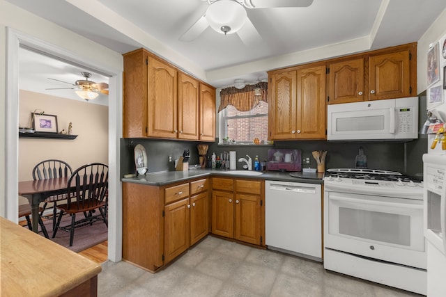 kitchen with white appliances, a sink, a ceiling fan, brown cabinets, and decorative backsplash