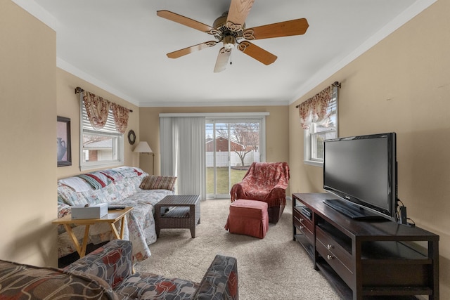 living room with carpet, a ceiling fan, and crown molding