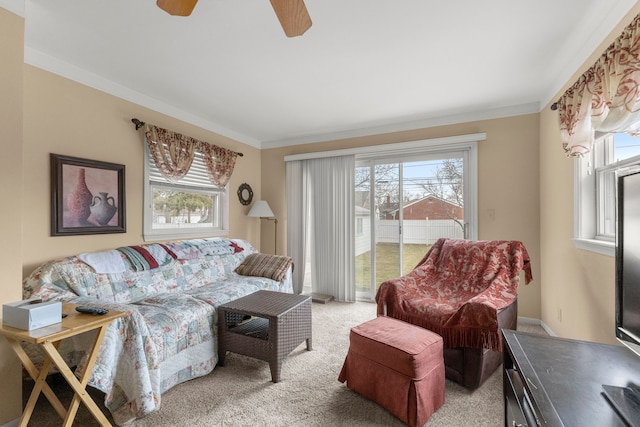 living room featuring a ceiling fan, light carpet, and crown molding