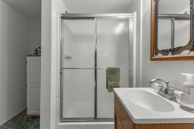 bathroom with a shower stall, baseboards, and vanity