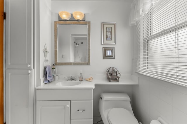 bathroom featuring a shower, vanity, toilet, and a healthy amount of sunlight