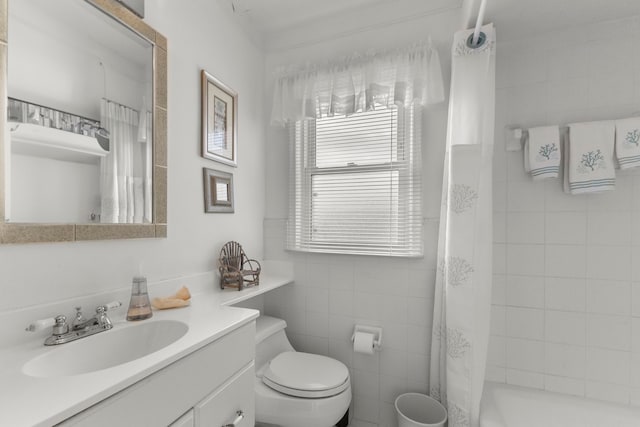 full bath featuring a tile shower, tile walls, toilet, and vanity