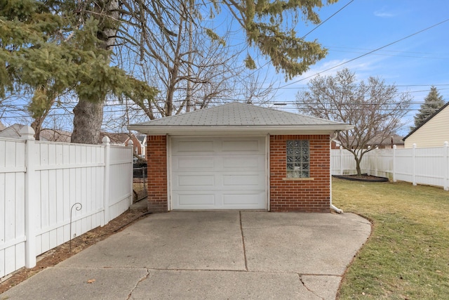 detached garage featuring driveway and fence