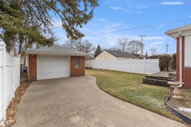 detached garage with fence and concrete driveway