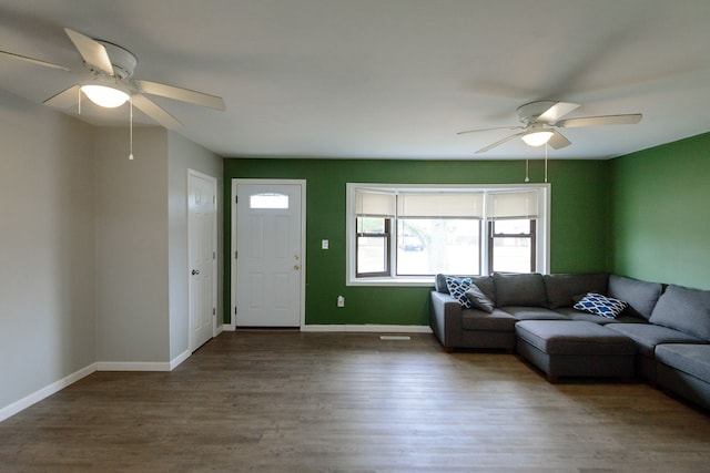 unfurnished living room with ceiling fan, baseboards, and wood finished floors