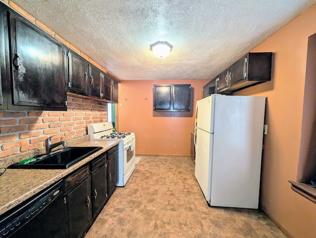 kitchen featuring a textured ceiling, white appliances, a sink, and baseboards