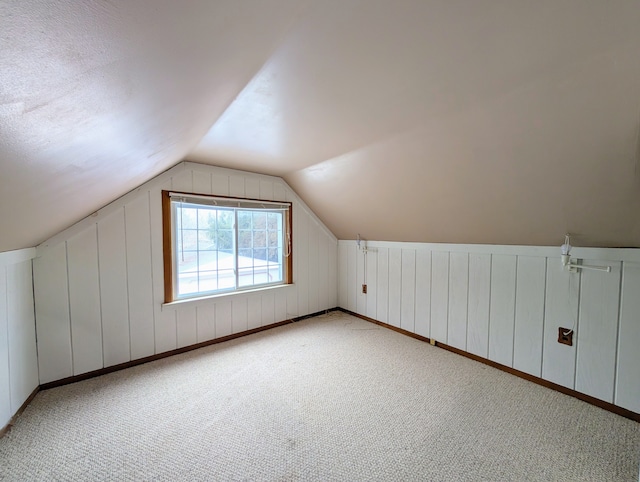 bonus room with lofted ceiling and carpet flooring