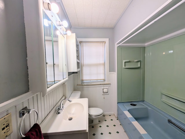 full bathroom with bathing tub / shower combination, toilet, wainscoting, vanity, and tile patterned floors