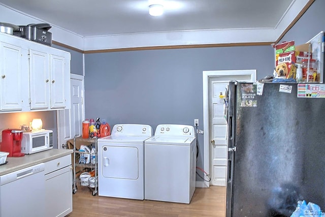 laundry area with light wood finished floors, cabinet space, and washer and dryer