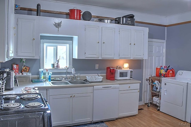 kitchen with light countertops, washer / clothes dryer, a sink, and white appliances