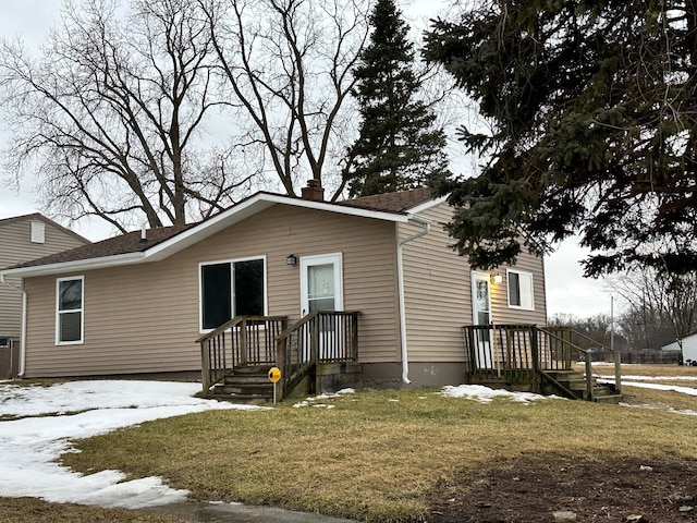 view of front of house featuring a chimney and a front yard