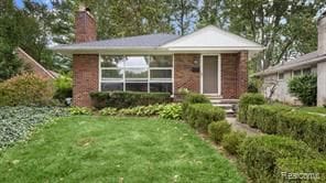 view of front of property featuring a front lawn and a chimney