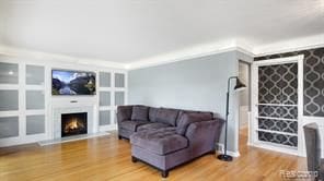 living room featuring a warm lit fireplace and wood finished floors