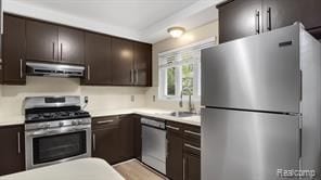 kitchen featuring appliances with stainless steel finishes, dark brown cabinetry, and under cabinet range hood