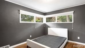 bedroom with dark wood-type flooring, multiple windows, and baseboards