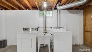 laundry room with laundry area, separate washer and dryer, and a sink