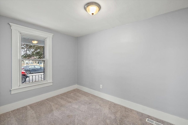 carpeted spare room with visible vents and baseboards