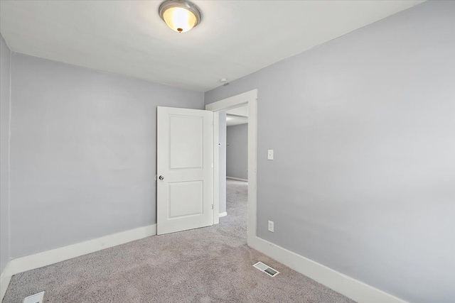 carpeted empty room with visible vents and baseboards