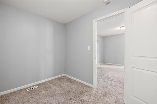 carpeted empty room featuring baseboards and visible vents