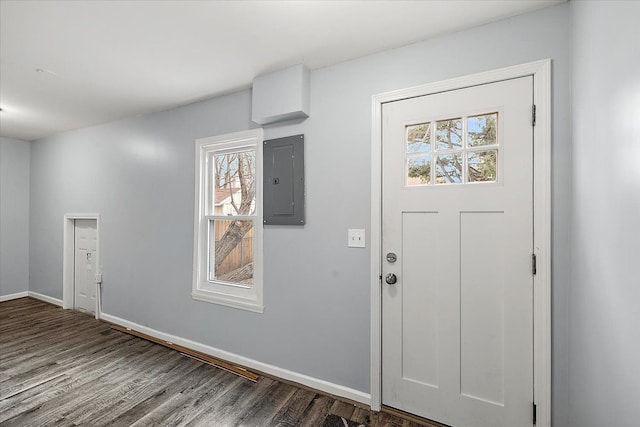 foyer with wood finished floors, electric panel, and baseboards