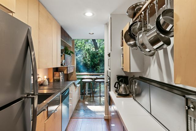 kitchen featuring dark wood finished floors, dark countertops, recessed lighting, appliances with stainless steel finishes, and expansive windows