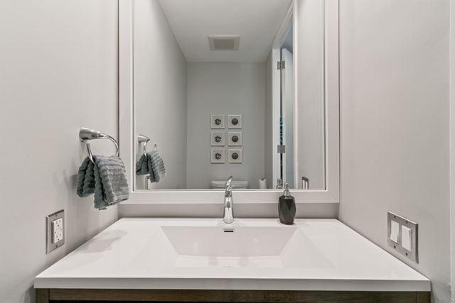 bathroom featuring toilet, visible vents, and vanity