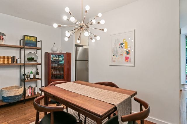 dining space featuring wood finished floors and a notable chandelier