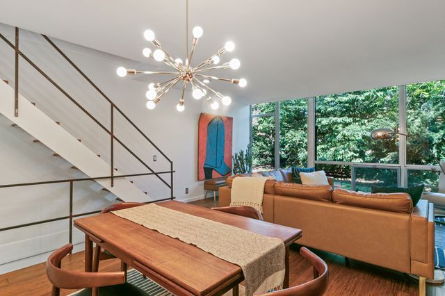 dining room with an inviting chandelier, floor to ceiling windows, and wood finished floors