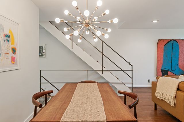 dining space featuring baseboards, a chandelier, and wood finished floors