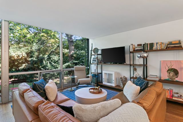 living room with a wealth of natural light, expansive windows, and wood finished floors