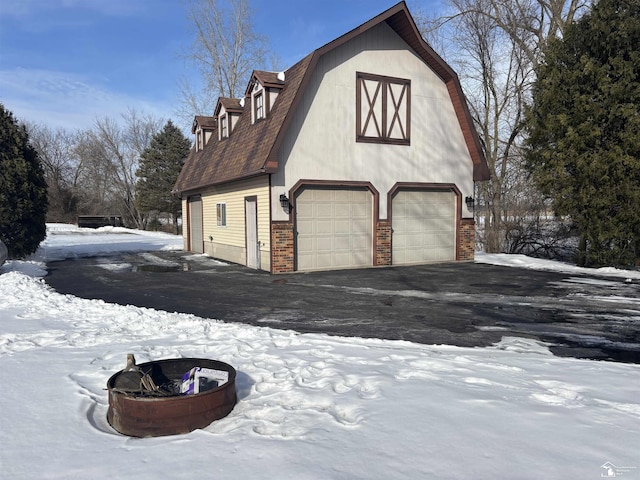 snow covered garage featuring a detached garage