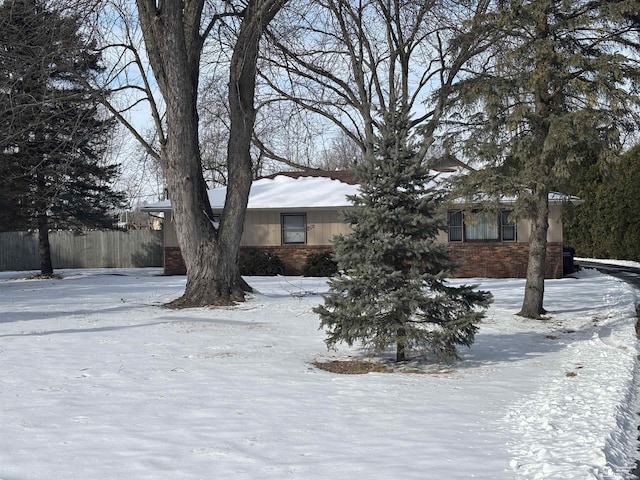 view of front of house featuring fence and brick siding