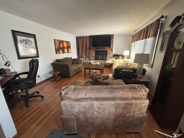 living room with a textured ceiling, a fireplace, and wood finished floors