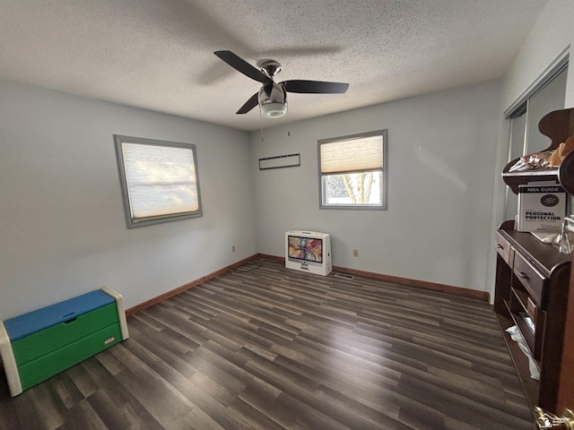 unfurnished bedroom with a textured ceiling, ceiling fan, wood finished floors, and baseboards