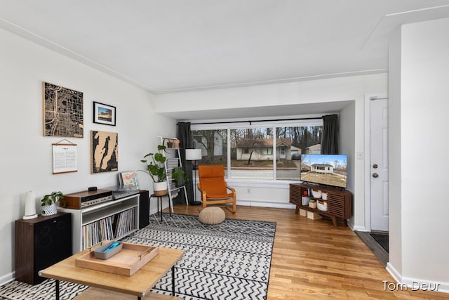 sitting room with baseboards and light wood finished floors