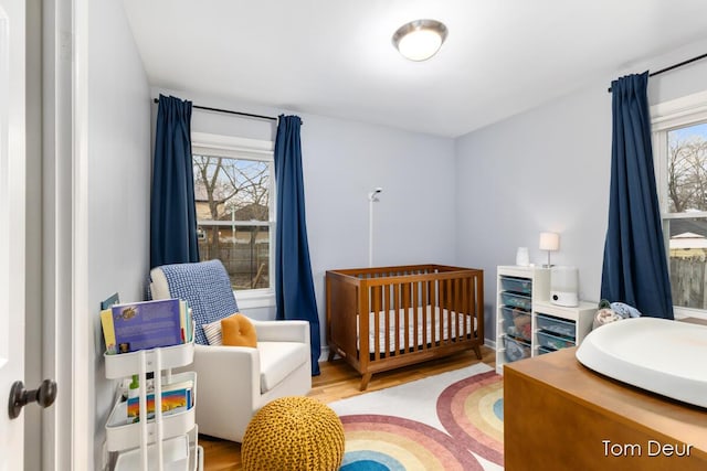 bedroom featuring a crib and wood finished floors