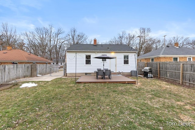 back of property with a fenced backyard, a yard, a chimney, and a wooden deck