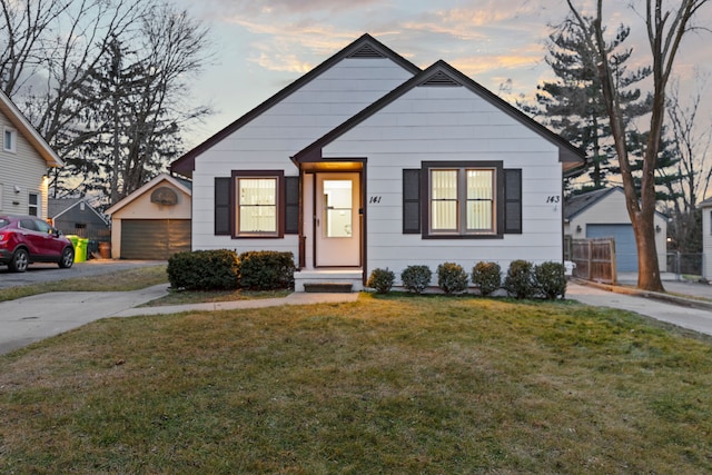 bungalow with a garage, a front yard, and an outdoor structure