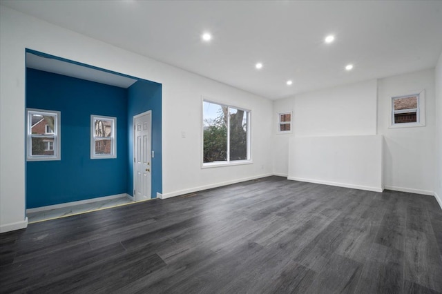 empty room featuring dark wood-type flooring, recessed lighting, and baseboards