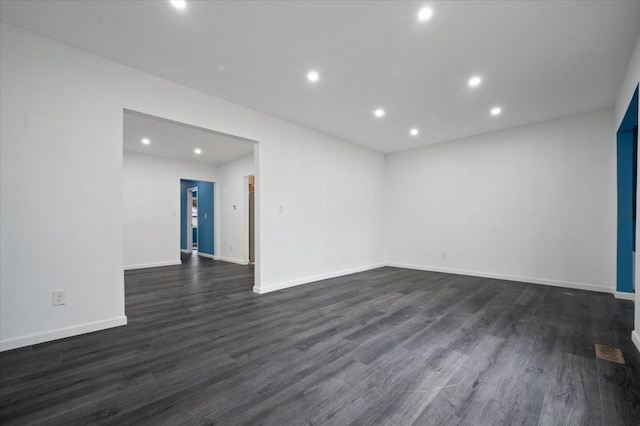 spare room with dark wood-style floors, baseboards, and recessed lighting