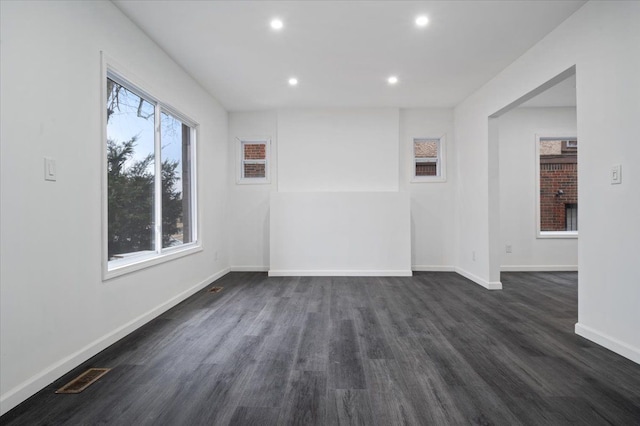 spare room featuring visible vents, baseboards, dark wood-type flooring, and recessed lighting