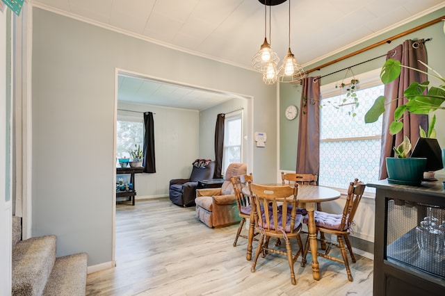 dining area with stairs, light wood-style floors, baseboards, and crown molding