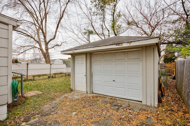 detached garage featuring fence