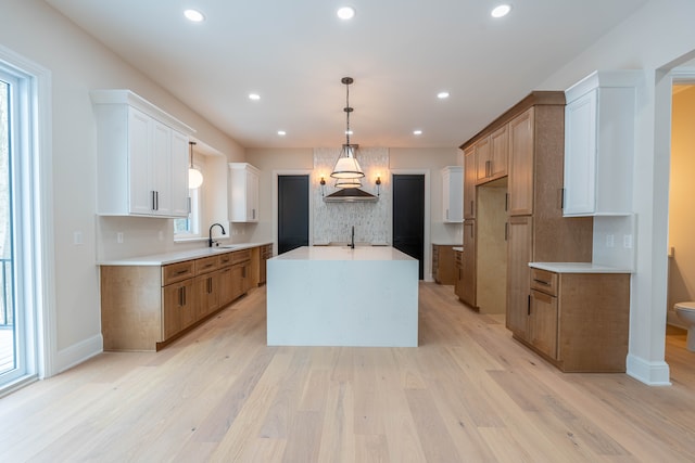 kitchen featuring light wood finished floors, recessed lighting, and backsplash